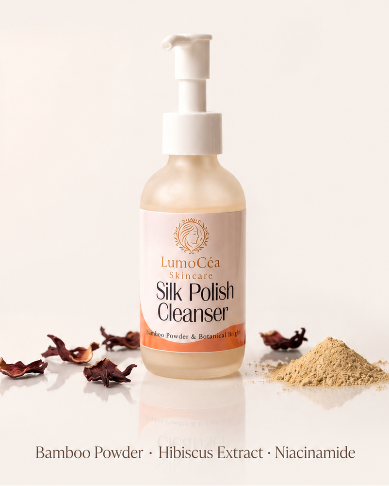 LumoCéa Silk Polish Cleanser pump bottle centered on a warm cream background, with decorative dried flowers and powder piles at the base and product text above.