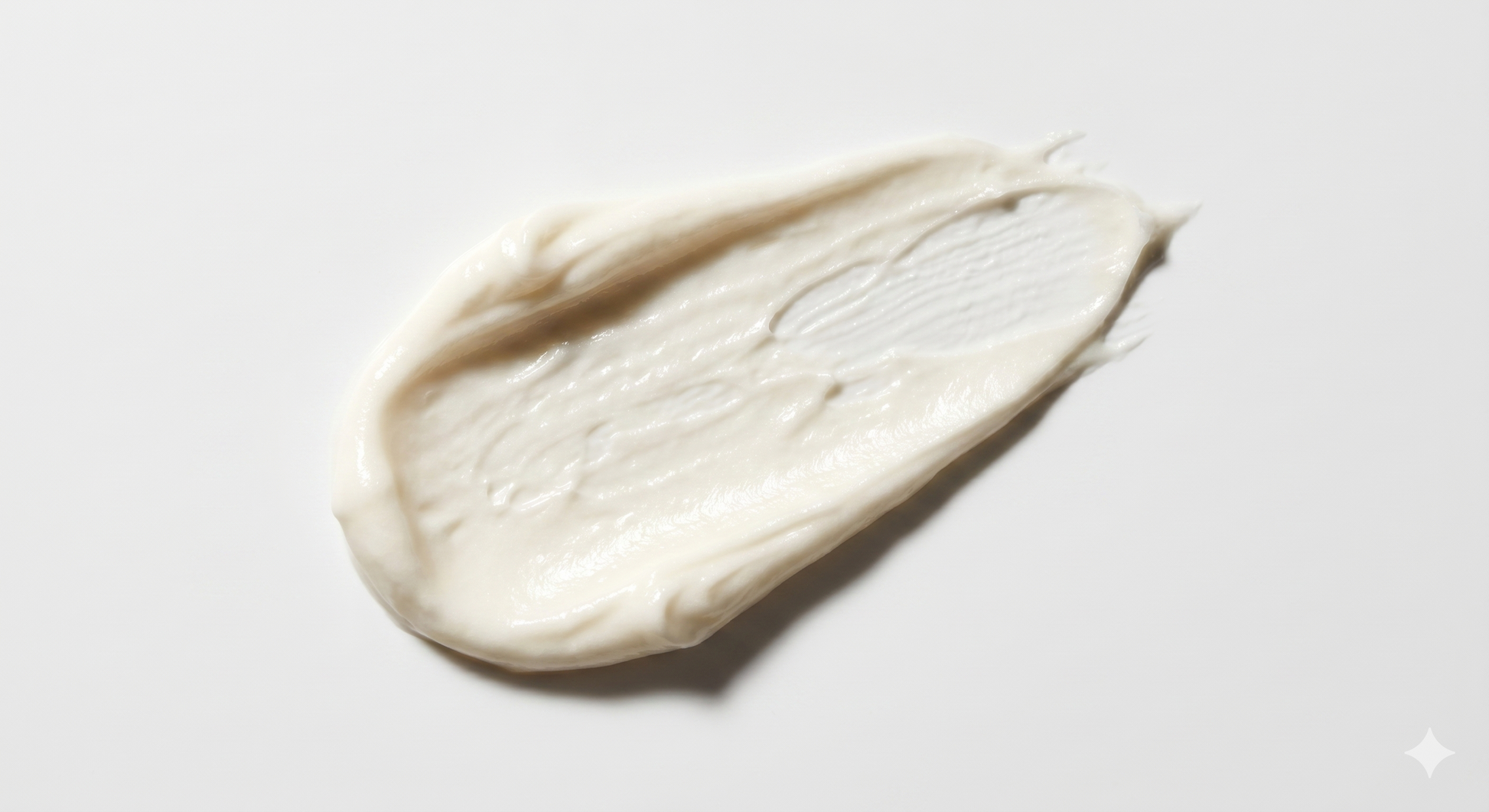 White cream or lotion smear on a light gray background